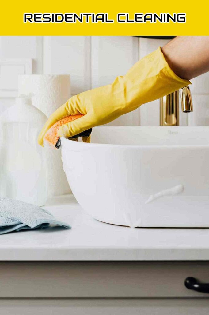 Shiny Cleaning Crew team member cleaning a bathroom sink. Bay Area Cleaning Services.